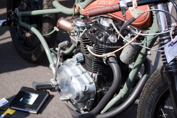 Mehrere Motorräder auf einem Parkplatz mit einem Buch in der Nähe.