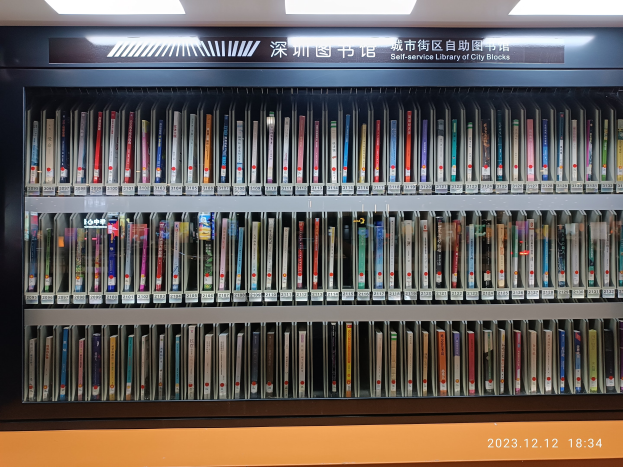 Eine hell erleuchtete Bibliothek mit hohen Regalen voller Bücher, mit einer Texttafel und einem Wasserzeichen unten.