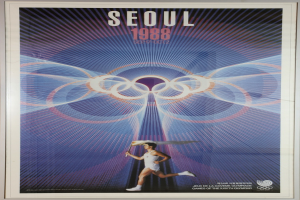 Eine Person, die mit den Olympischen Ringen im Hintergrund läuft und die Worte "Olympische Spiele" über den gesamten oberen Bereich des Plakats für die Olympischen Spiele 1988 in Seoul, Südkorea, geschrieben sind.