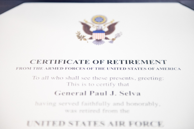 Rahmenurkunde für den Ruhestand der United States Air Force mit blauem Rand, die ein zentrales Schild-Logo mit einem Stern, einem Lorbeerkranz und einer schwarzen Schriftzeile "Ruhestand" zeigt.