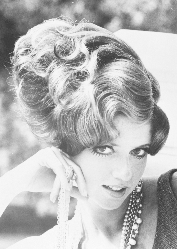 Schwarzes und weißes Foto von Prinzessin Diana in einem Kleid und Schmuck mit unscharfem Hintergrund.