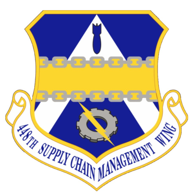 Logo der 48. Supply Chain Management Wing mit einem blauen Schild, einem weißen Stern und einem weißen Banner mit der Aufschrift "Supply Chain Management" in blau, alles von einem weißen Rand und schwarzer Schrift umgeben.
