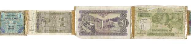 Ein altes Buch mit einem Stapel verschiedener alter deutscher Banknoten darauf.