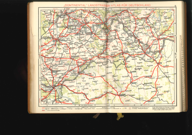 Offenes Buch mit einem detaillierten Straßenkarten-Plan von Deutschland auf schwarzem Hintergrund.