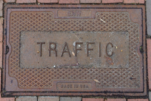 Ziegelweg mit einer Metallschachtdüse, die mit "Verkehr" beschriftet ist
