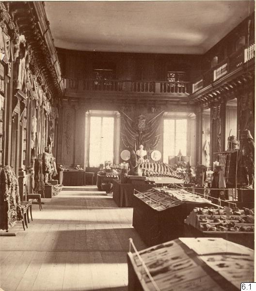 Schwarz-weiß-Fotografie eines Raums im Museum of Fine Arts, London, mit Tischen, Stühlen, Wandskulpturen, Fenstern mit Vorhängen und Geländern.