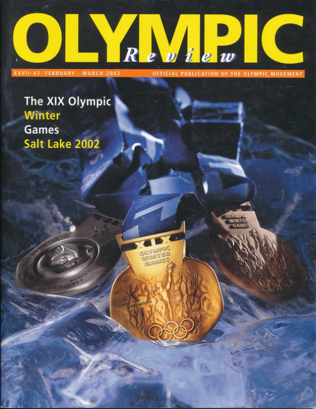 Ein Buch mit dem Titel "Olympische Spiele-Revue" mit mehreren Medaillen in verschiedenen Größen und Farben und fett gedrucktem Text auf dem Cover.