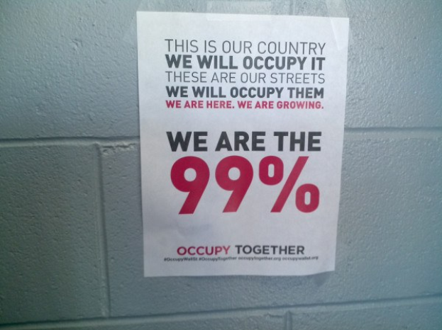 Plakat an einer Wand mit fettem schwarzem Text, der "Occupy Wall Street" und "Wir sind die 99%" lautet.