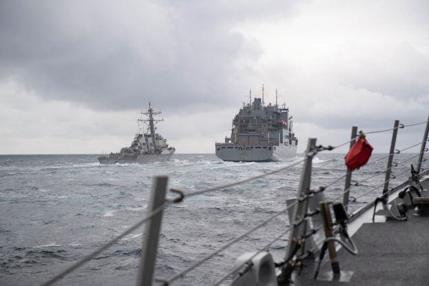 Zwei Schiffe auf dem Meer mit bewölktem Himmel, ein Schiff rechts mit sichtbaren Relings und Seilen, das andere links.