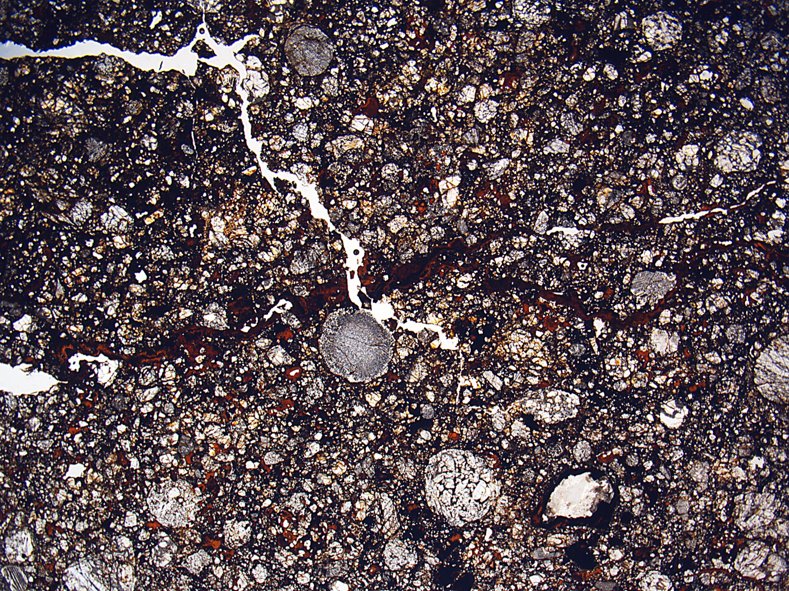 Nahaufnahme einer rissigen, schmutzigen Straße mit rauer, unebener Oberfläche.