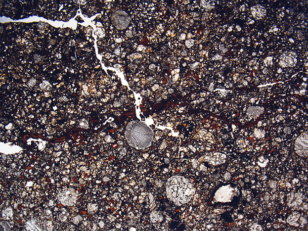 Nahaufnahme einer rissigen, schmutzigen Straße mit rauer, unebener Oberfläche.