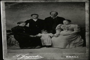 Ein Schwarz-Weiß-Foto einer Familie in festlicher Kleidung mit handgeschriebener Unterschrift.