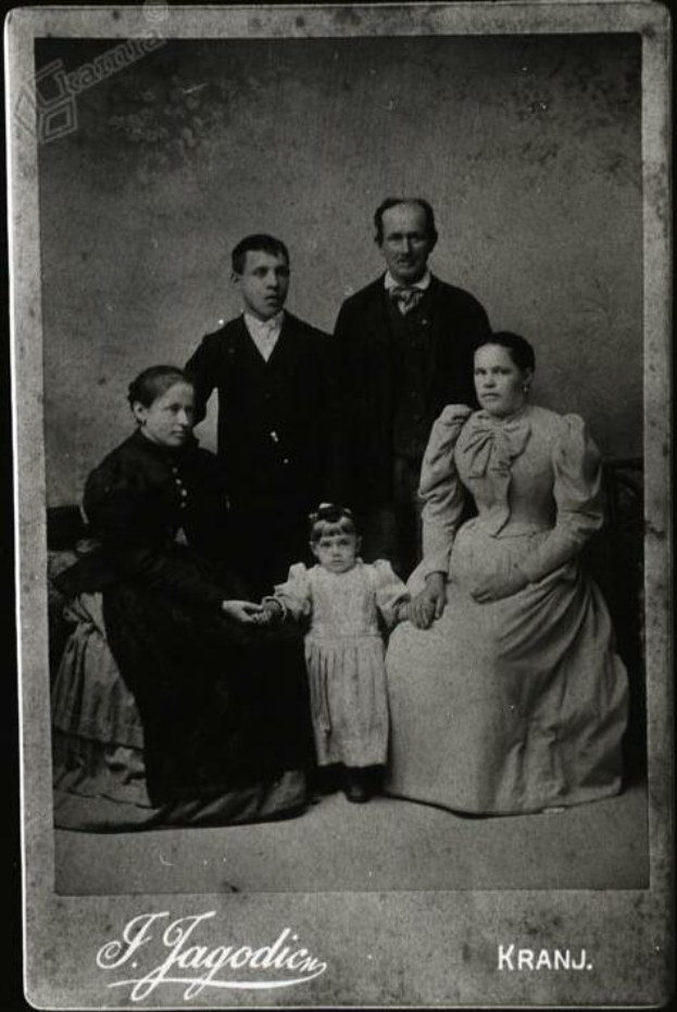 Ein Schwarz-Weiß-Foto einer Familie in festlicher Kleidung mit handgeschriebener Unterschrift.