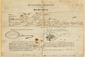 Ein altes, gelbliches Dokument mit einem kreisrunden, schwarz umrandeten Stempel, das schwarze Text in deutscher Sprache enthält, wahrscheinlich vom deutschen government.
