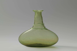 Ein grüner Glasweinkelch mit Verschluss, zylindrischer Form, breiter Basis, engem Hals und detaillierten Verzierungen, mit glänzendem Finish.