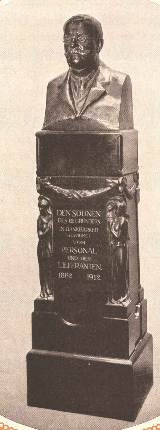 Schwarzes und weißes Foto einer Büste eines Mannes im Anzug und Krawatte, mit Gedenktext beschriftet, vermutlich ein Denkmal für den Gründer der deutschen Volksbefreiungsbewegung.
